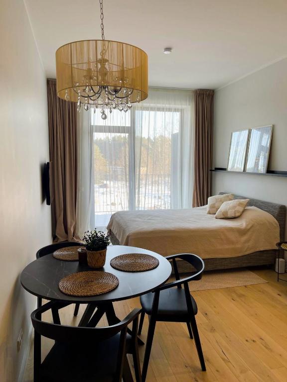 a bedroom with a bed and a table with chairs at Albatross Relax seaside in Ķesterciems