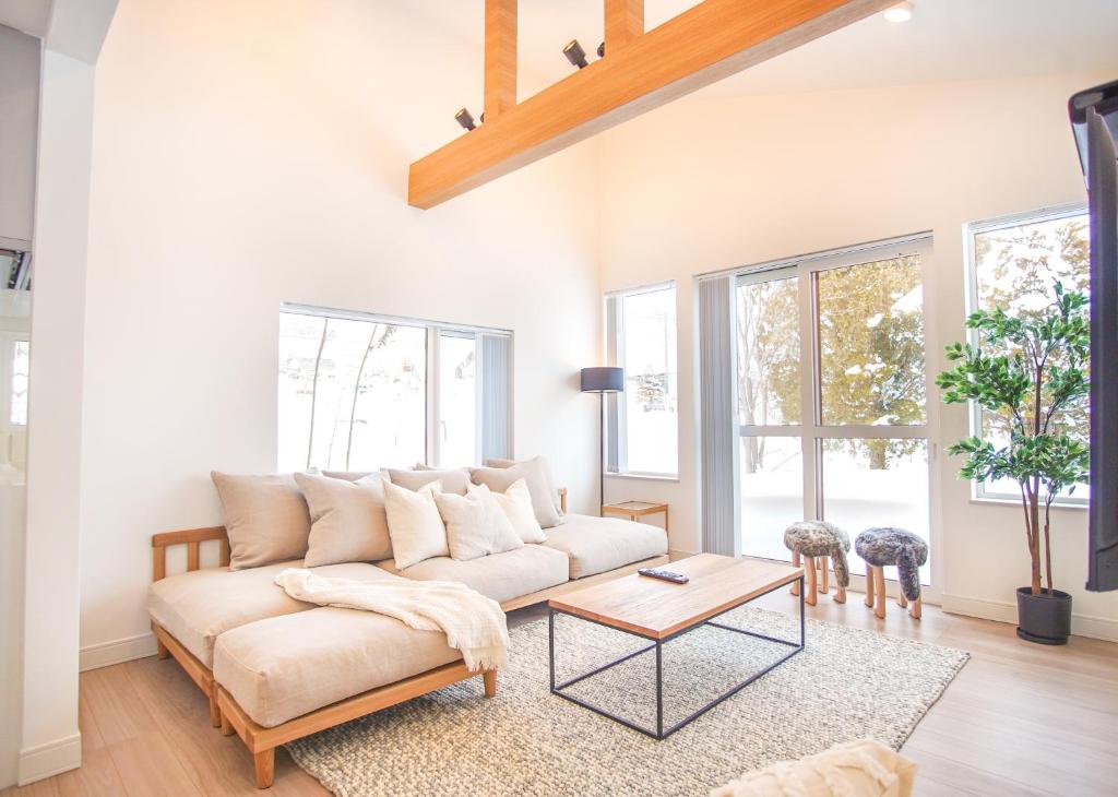 a living room with a couch and a table at Grouse Lodge -5 mins to ski field by walk- in Furano