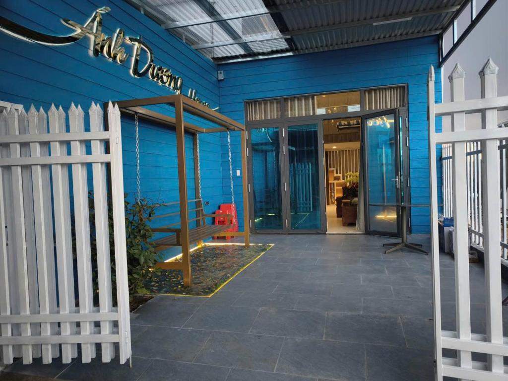 a blue building with a fence in front of it at Ánh Dương House 2 in Da Thanh