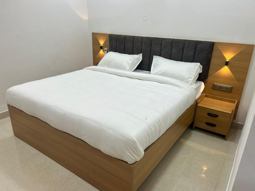 a bedroom with a large bed with white sheets and pillows at ChanTini Inn in Velankanni