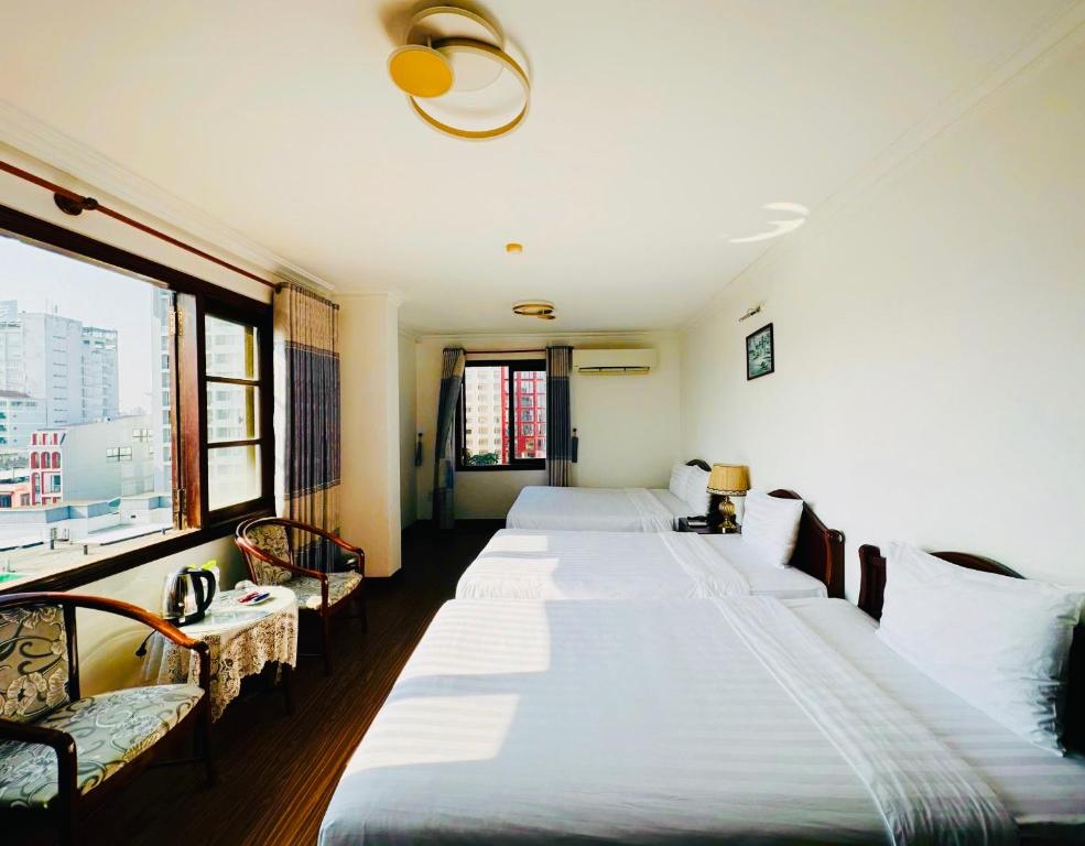 Phòng nghỉ tại Cosiana Hue Hotel sử dụng nội thất gỗ và cửa kính lớn, tạo không gian sáng thoáng; nhiều phòng có ban công riêng hướng thành phố hoặc khu vực sông.