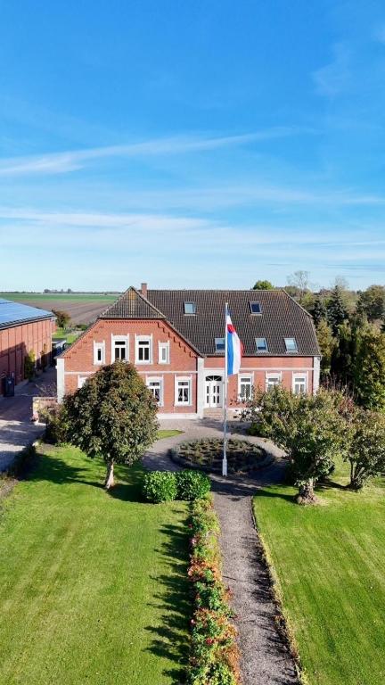 a red brick house with a flag in a yard at Bauernhuus 5 in Fehmarn