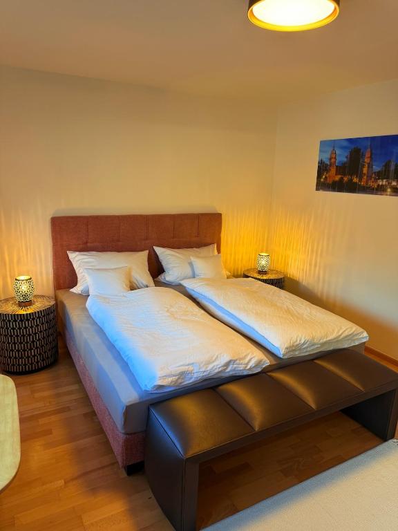 a bedroom with two beds and a bench in it at Freudenstadt City Apartment in Freudenstadt