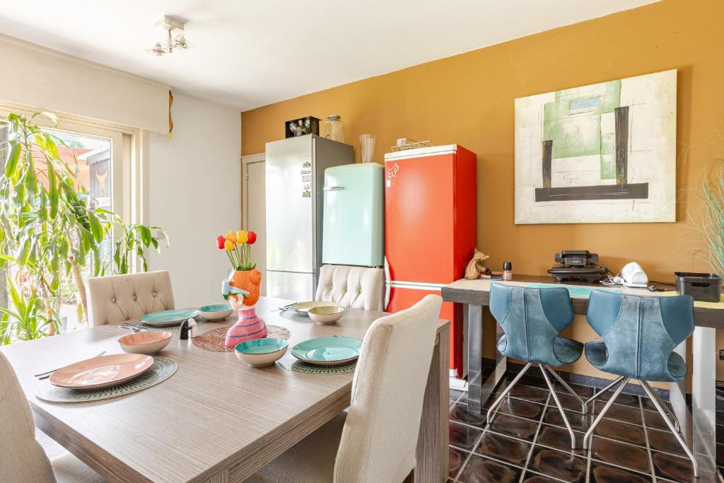 a kitchen with a wooden table and a refrigerator at Steves Place Haasdonk in Beveren