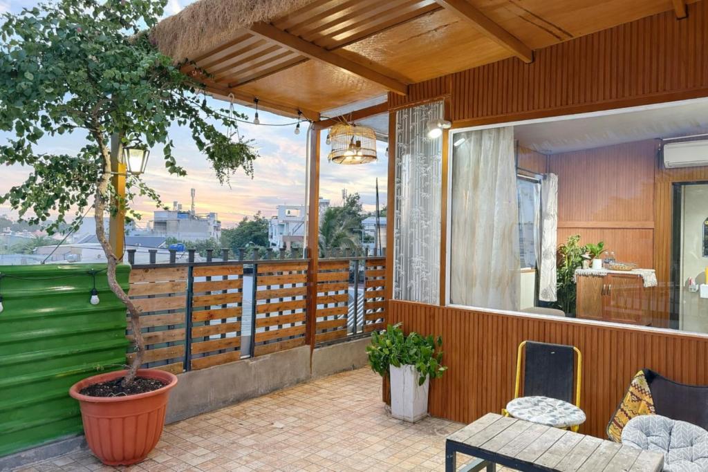 a balcony with a table and a potted tree at Nature House Homestay in Ho Chi Minh City