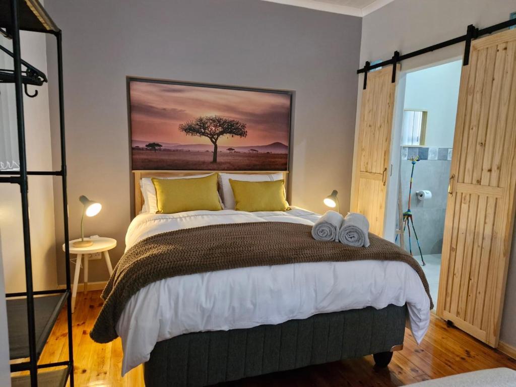 a bedroom with a bed with two towels on it at Cosy cottage on Cassia in Gqeberha
