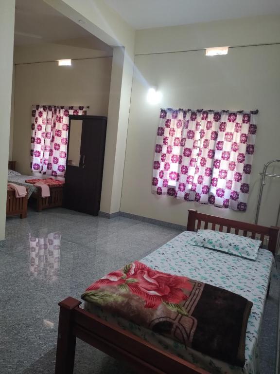 a room with two beds and a painting on the wall at Bridgettine Paradise in Sultan Bathery