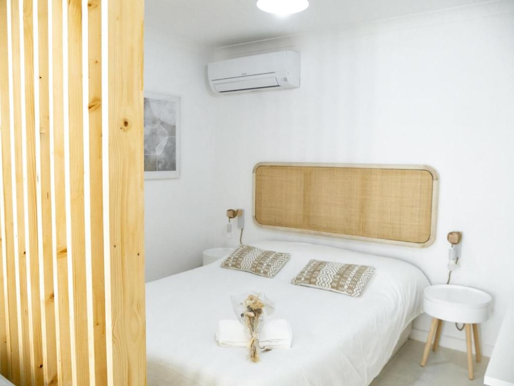 a white bedroom with a bed and a sink at Alcácer do Sal Hideaway in Alcácer do Sal
