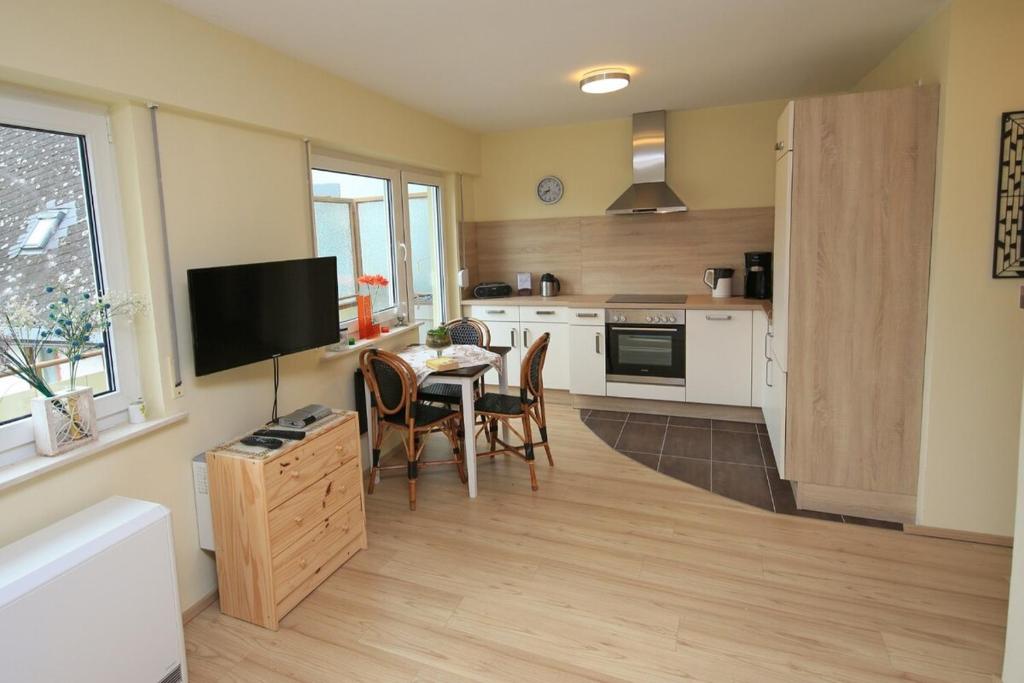 a kitchen with a table and a tv in a room at Ferienwohnung Fine in Lorch am Rhein