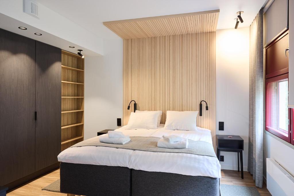 ein Schlafzimmer mit einem großen Bett, auf dem Handtücher liegen in der Unterkunft Hotel Linnasmäki in Turku