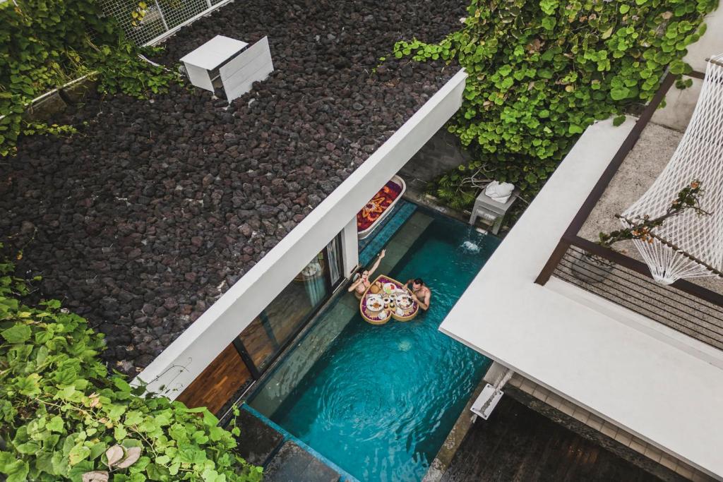 an overhead view of a swimming pool with a raft in a house at Ayona Villa Seminyak by Ini Vie Hospitality in Seminyak