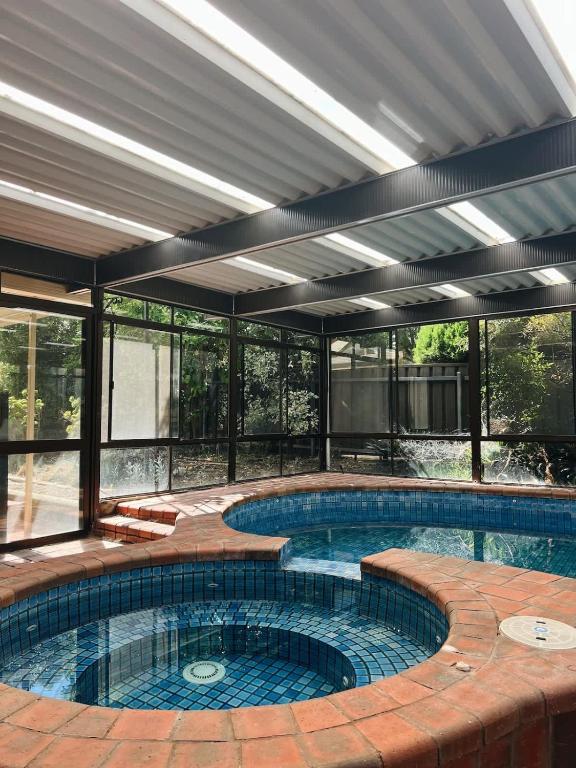 a large swimming pool in a building with a building at Casa Lonita - Indoor Pool & Spa in Beechworth