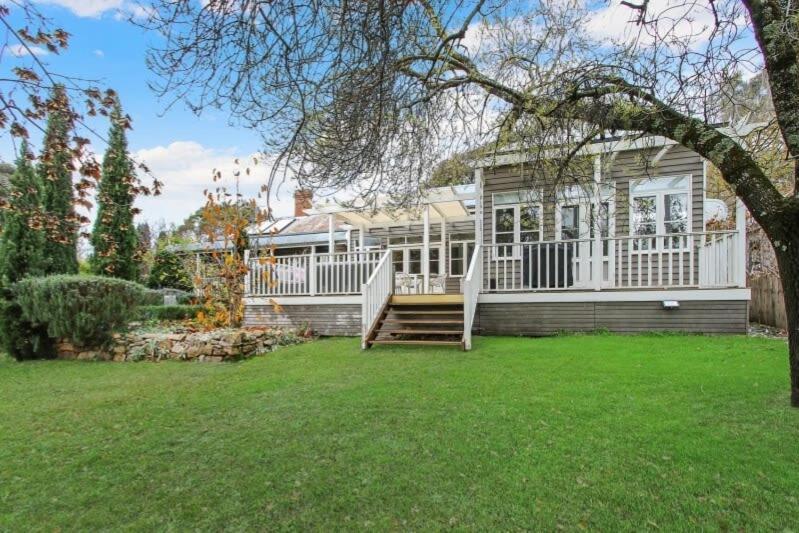 a large white house with a porch and a yard at Malakoff House - Charm & Luxury in Beechworth