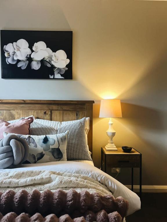 a bedroom with a bed with a picture on the wall at The Sunset Deck in Beechworth