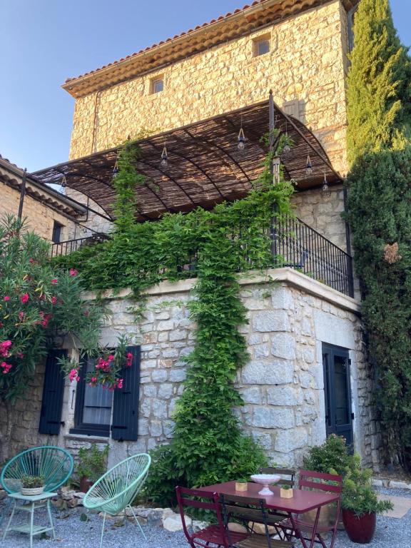 a building with a table and chairs in front of it at La Stévenière Gîte et Chambre d'hôtes in Chandolas