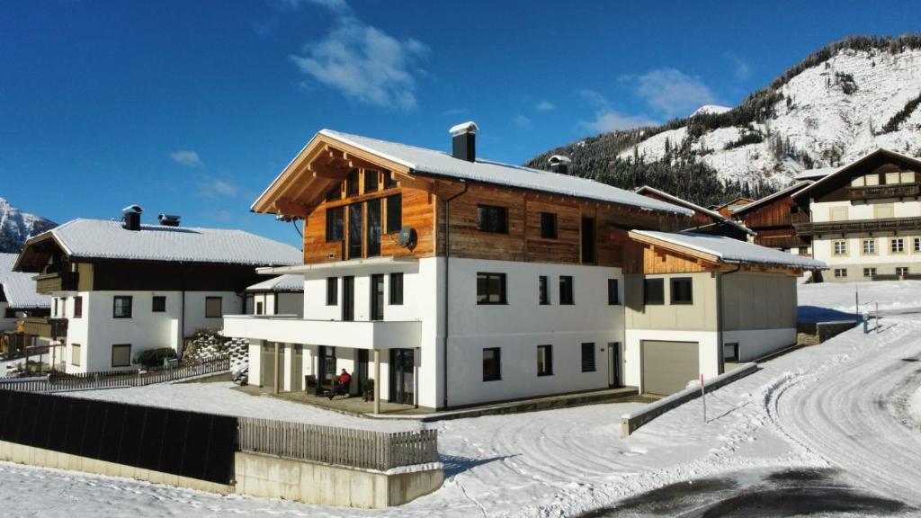 a house in the snow with a mountain at Apart s'Peintl in Obertilliach