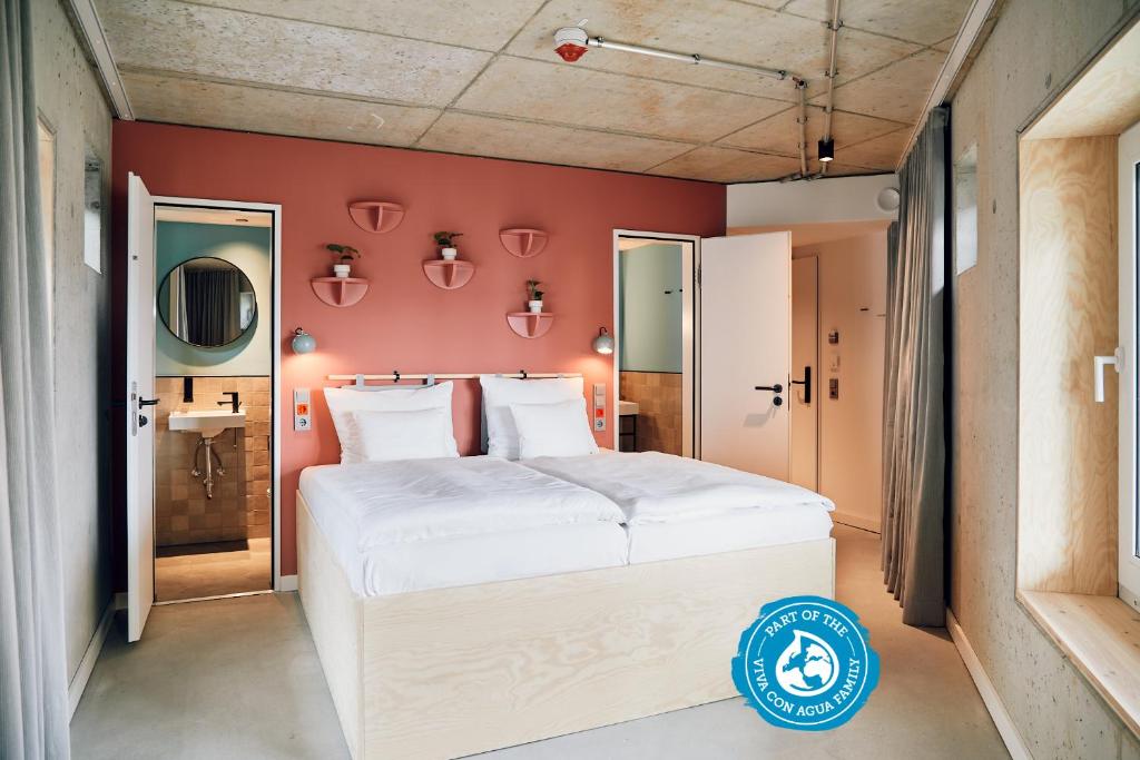 a bedroom with a large white bed and a red wall at Villa Viva - ein Haus das Brunnen baut in Hamburg