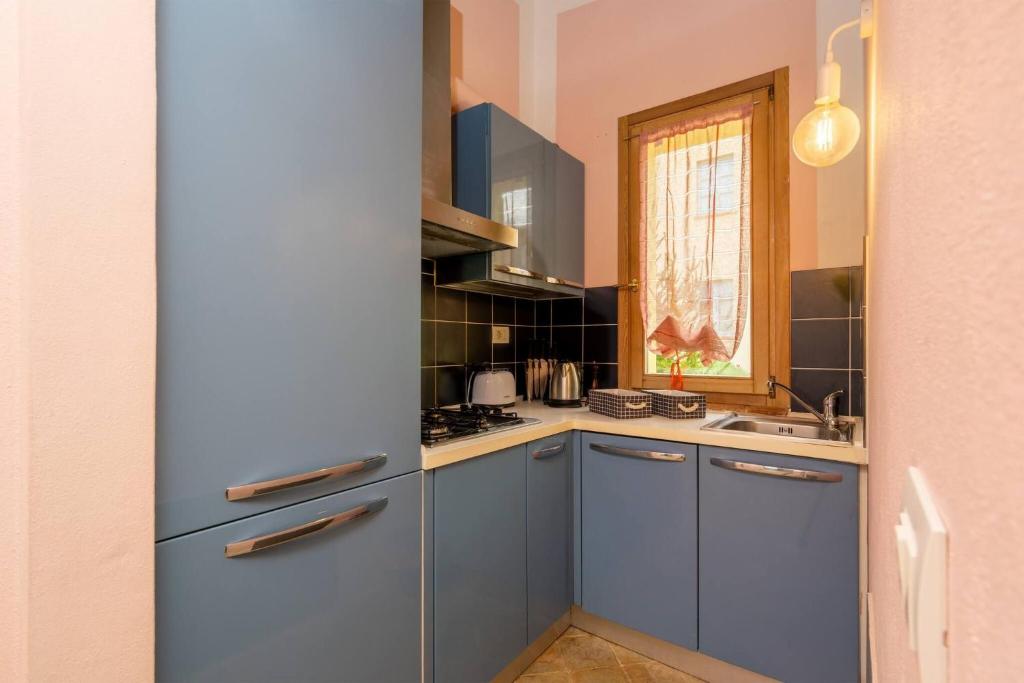 a kitchen with blue cabinets and a sink at Chalet Cigno - Apartment in Tuscany in Osteria Delle Noci