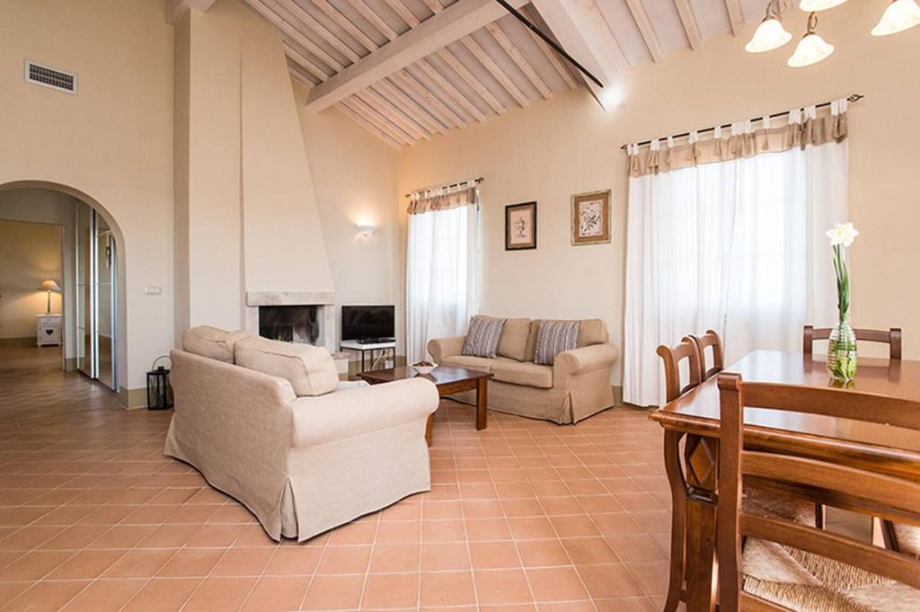 a living room with a couch and a table at Quercia Apartment - Cignella Resort Tuscany in Osteria Delle Noci