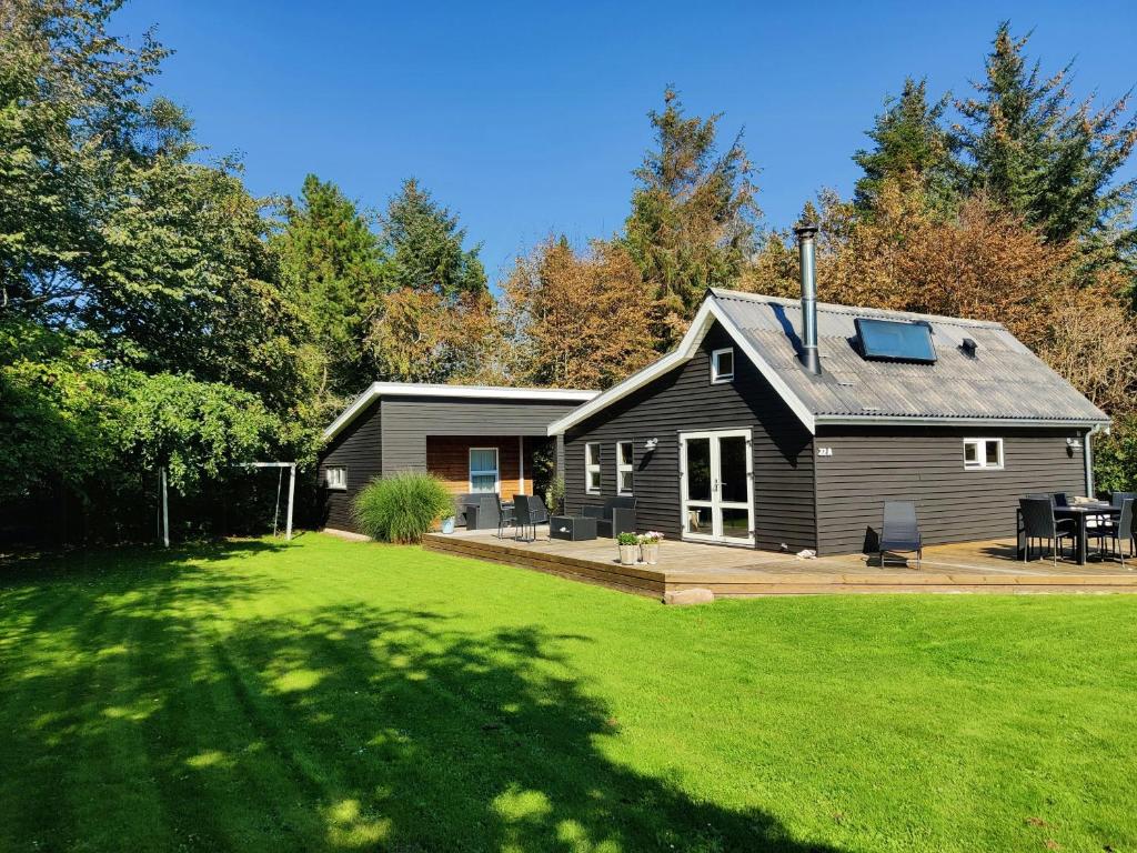 a small black house with a large yard at Home Near Beach With Wilderness Bath in Sindrup