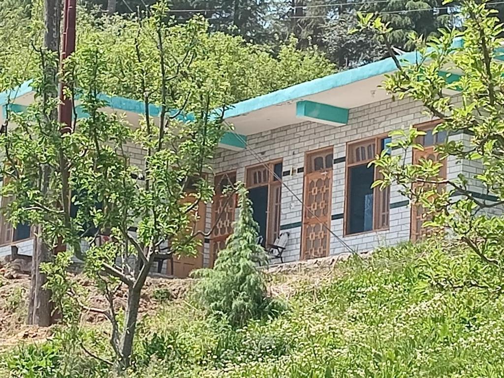a house is seen through the trees at Apple Zone Home stay in Banjār