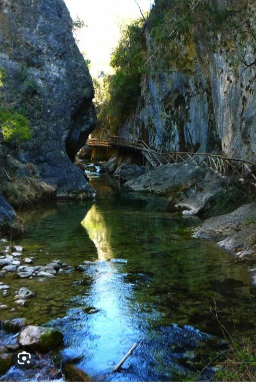 a river with a bridge and some rocks and water at Refugio Ruta Río Borosa in Coto Ríos