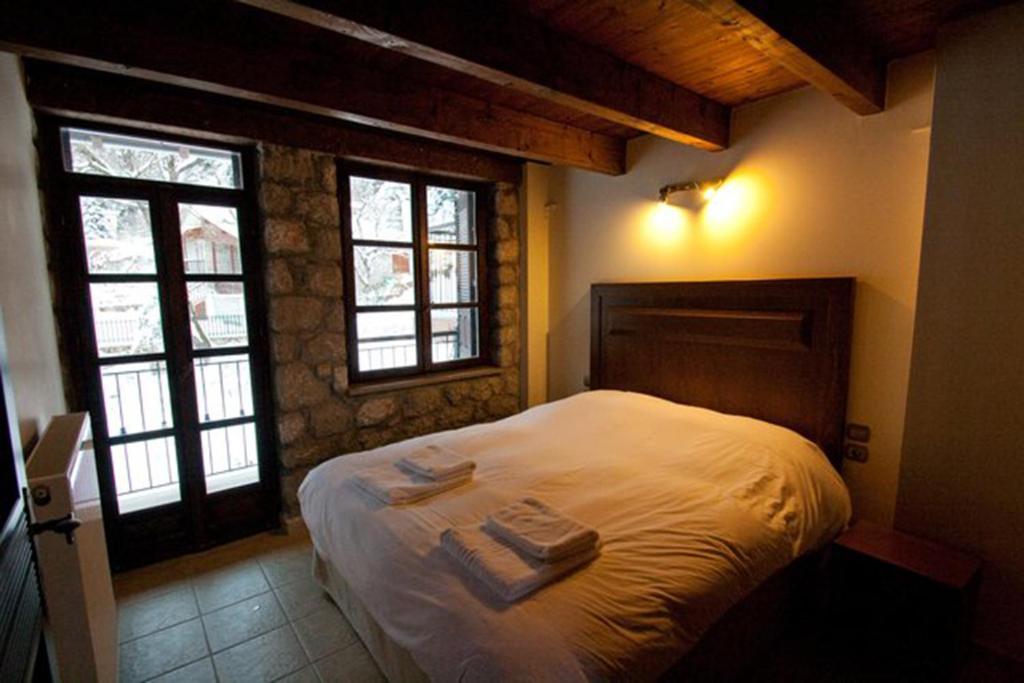 a bedroom with a bed with two towels on it at Chalet Christantoni in Elati Trikalon