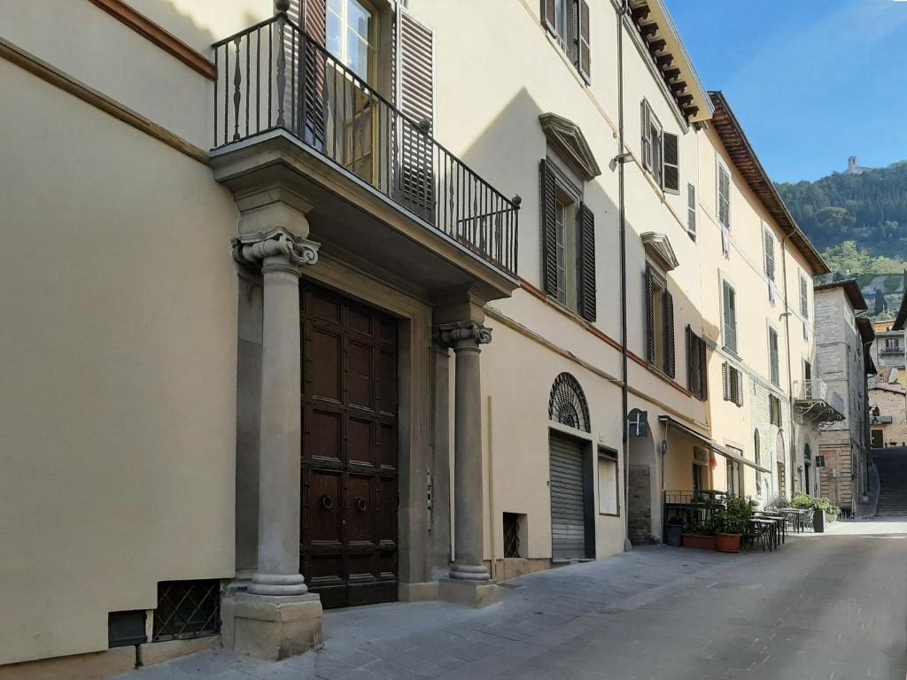 a building with a large wooden door and a balcony at Il Cortile delle magnolie in Gubbio