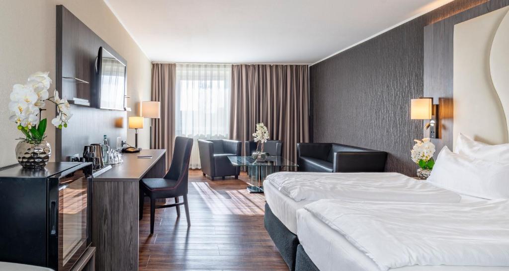 a hotel room with a bed and a desk at PLAZA INN Grevenbroich in Grevenbroich