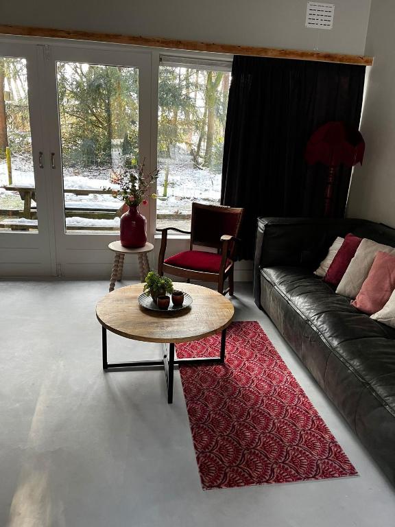 a living room with a couch and a table at Bonte Specht in Otterlo