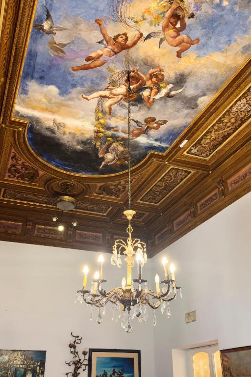 a painting on the ceiling of a room with a chandelier at Antica Dimora Caruso in Catania