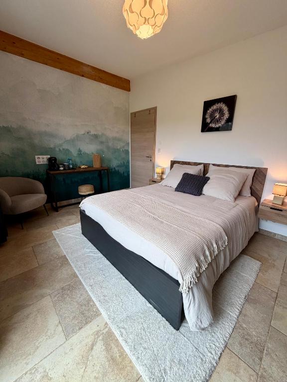 a bedroom with a large bed and a couch at Entre sabots et ronrons in Butten
