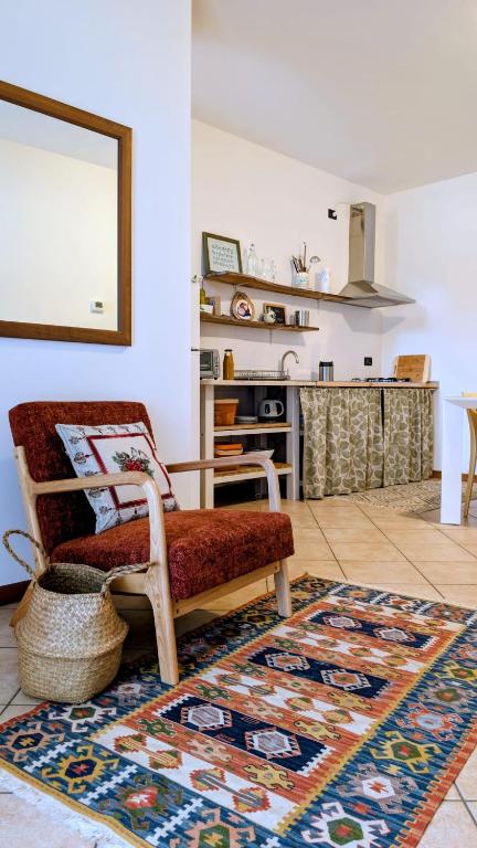 a living room with a chair and a rug at La casa di Lino in Volta Mantovana