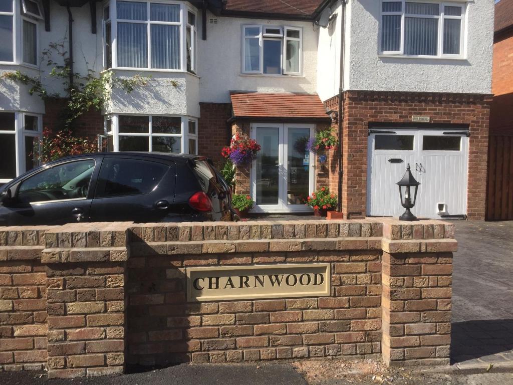 a sign on a brick wall in front of a house at Charnwood Guest House in Shrewsbury