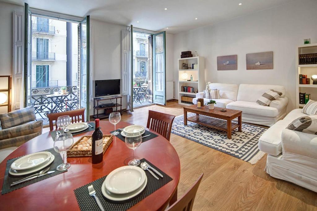 ein Wohnzimmer mit einem Tisch und einem Sofa in der Unterkunft Habitat Apartments Bruc Terrace in Barcelona