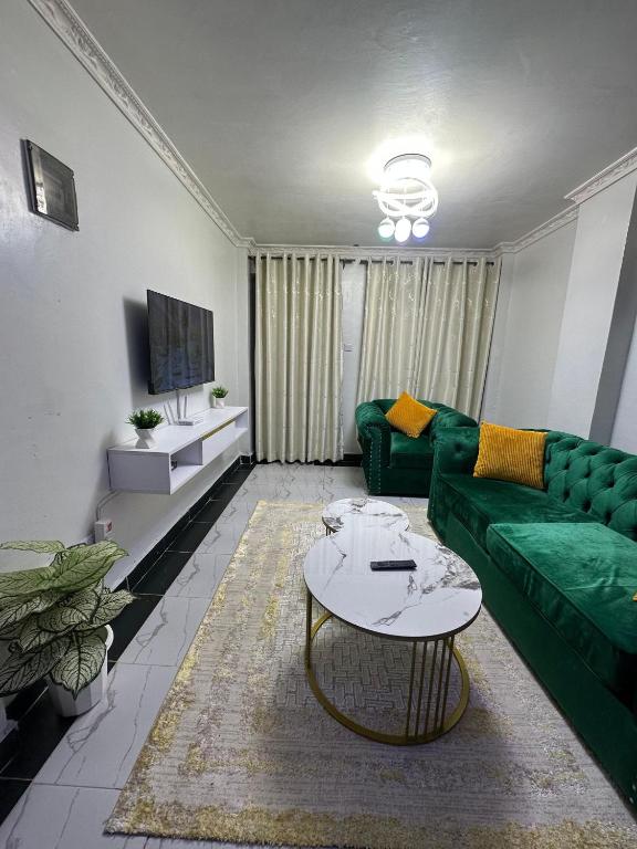 a living room with a green couch and a table at Infinite Stays in Thika