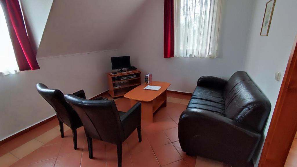 a living room with a couch and chairs and a table at Batthyány Villapark in Zalacsány