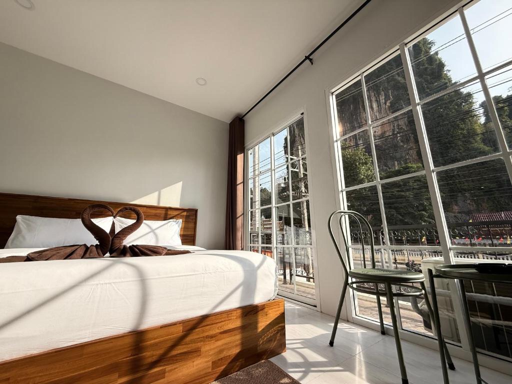 a bedroom with a bed and a chair and windows at Chailai room202 in Ban Sai Thai