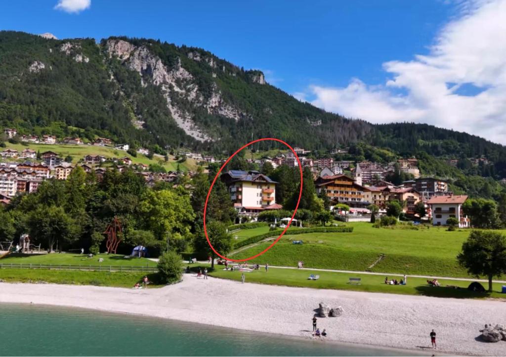 a red circle on a beach next to a mountain at Lake&Nature Hotel Gloria in Molveno