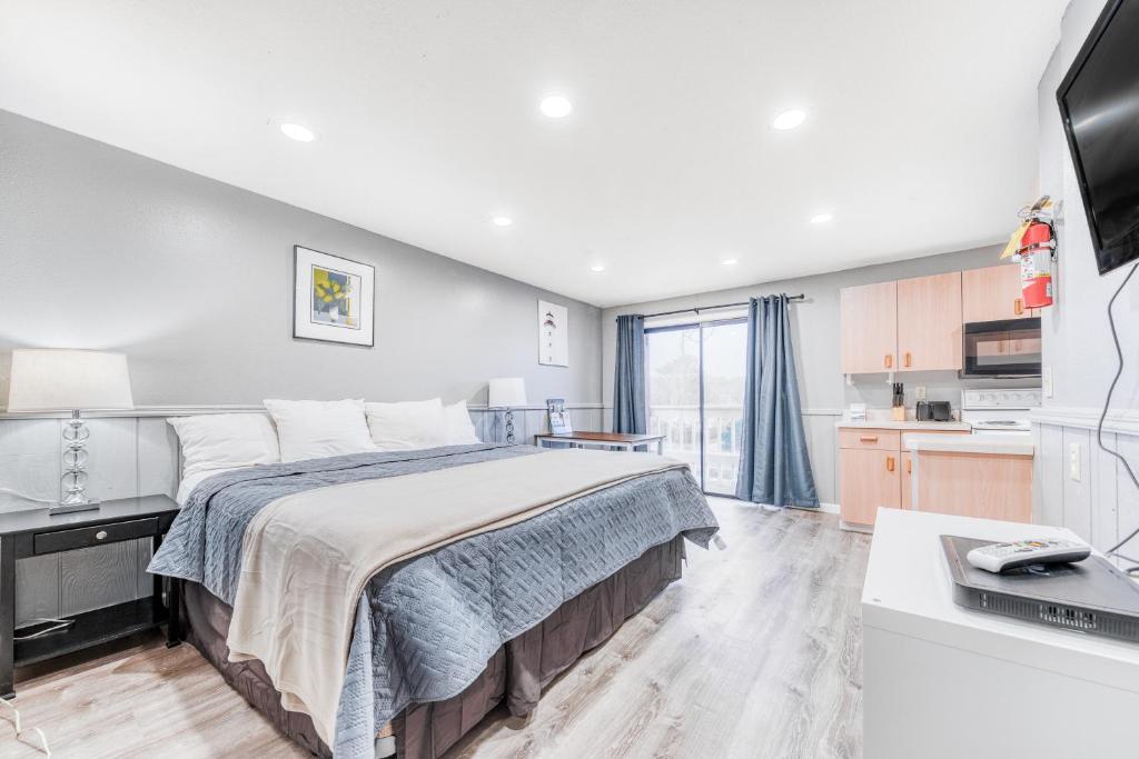 a bedroom with a large bed and a kitchen at Sea Treasures Inn Unit #212 in Rockaway Beach