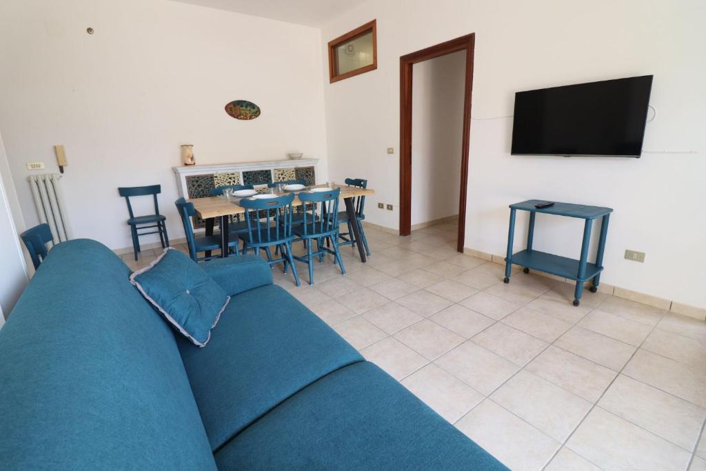 a living room with a blue couch and a table and chairs at Casa Giselle in Otranto in Otranto