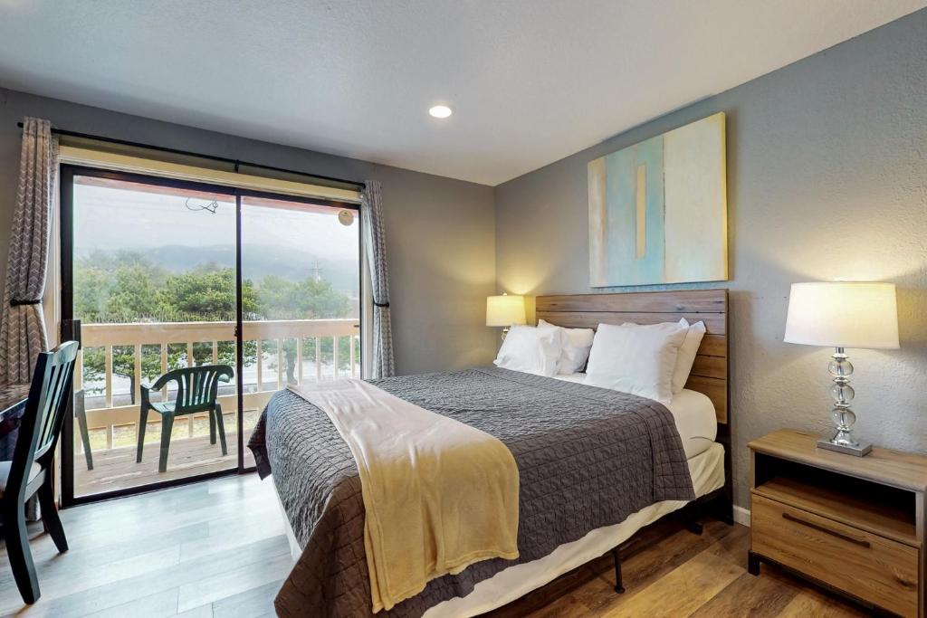 a bedroom with a bed and a balcony at Sea Treasures Inn #211 in Rockaway Beach