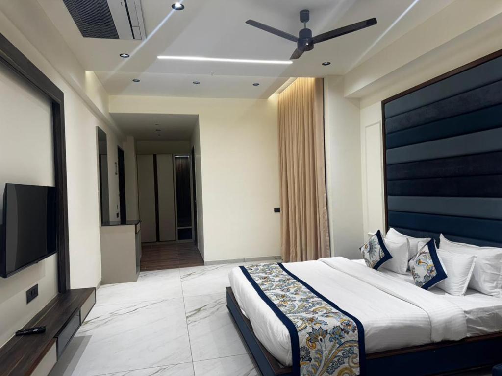 a bedroom with a large bed and a flat screen tv at Lords Swastik Studio Kodinar in Kodīnar