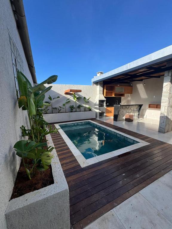 a swimming pool on a wooden deck next to a building at Lofts Clariô in Alto Paraíso de Goiás