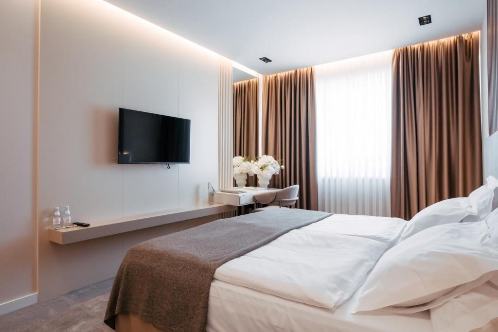 a hotel room with a bed and a television at Hotel Restaurant Kod Barića in Grude