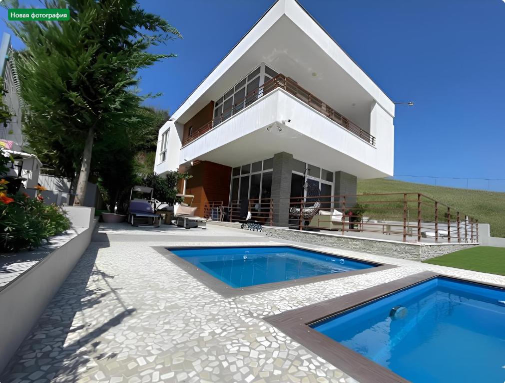 a house with a swimming pool in front of it at Farka Lake Luxury Villa in Tirana