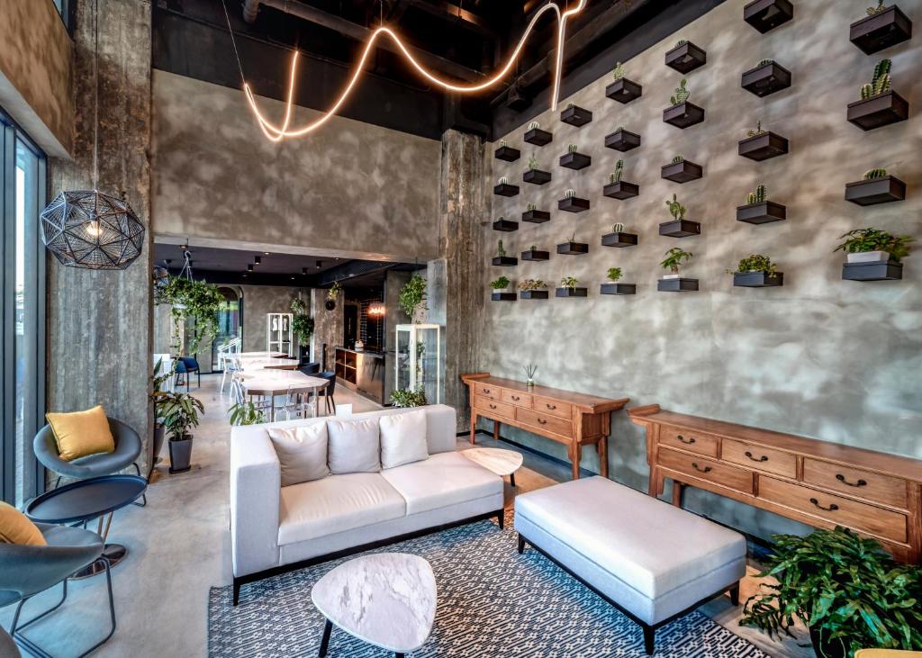 a lobby with a couch and tables and chairs at Oootopia Kai Tak in Hong Kong