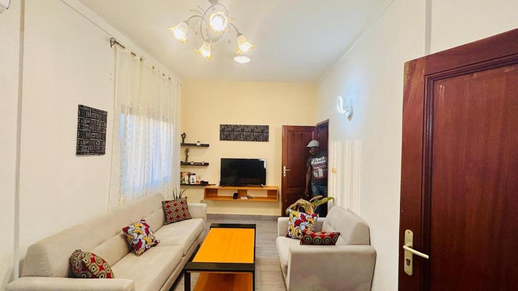 a living room with a couch and a tv at Appartement - BIOKOU - Route des pêches in Cotonou