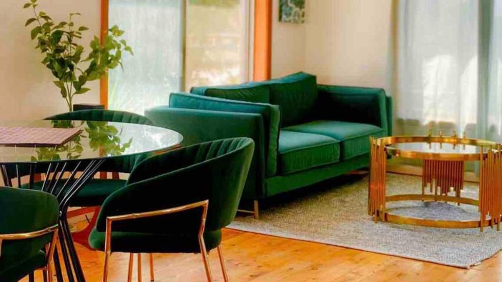a living room with a green couch and a table at Little Red Brick House in Padstow