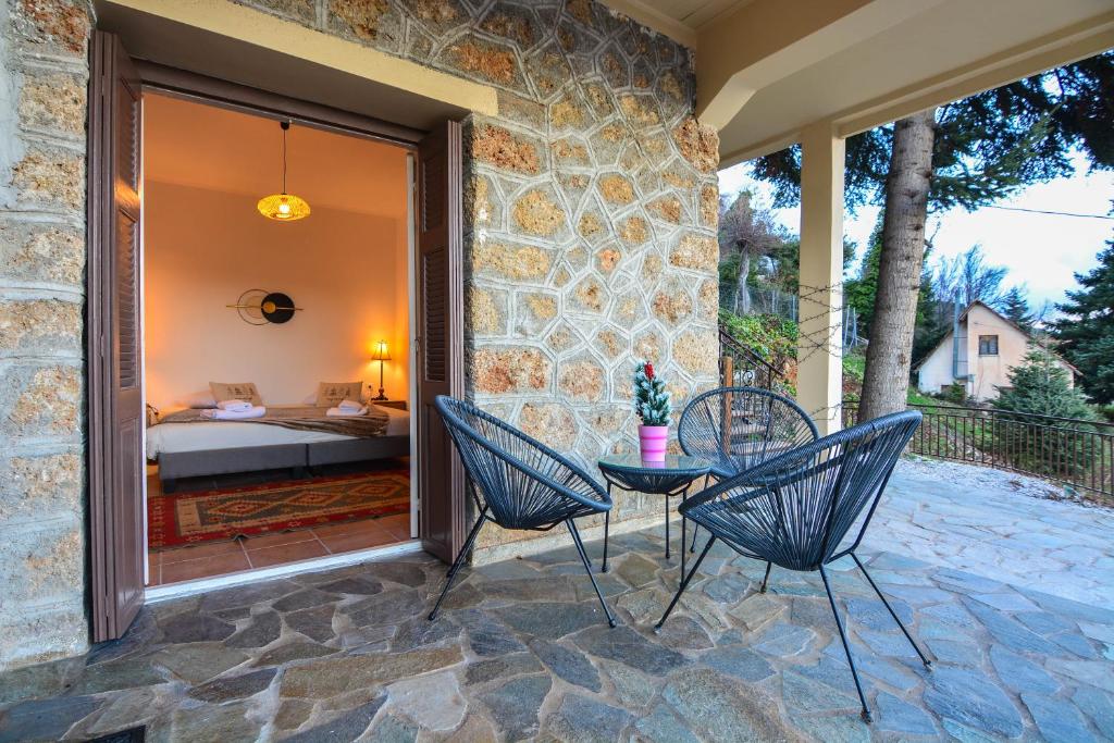 a patio with a table and chairs and a bedroom at Casa di Fiamengo in Ano Trikala